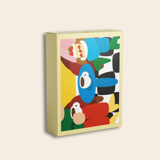 The Kaffee Und Kuchen | 99 Piece Jigsaw Puzzle by Das Puzzle Kollektiv comes in a rectangular box adorned with a vibrant abstract illustration of cartoon-like characters in blue, red, green, and yellow on a light beige background. Made from recycled paper, this puzzle is perfect for your next Kaffee Und Kuchen gathering.