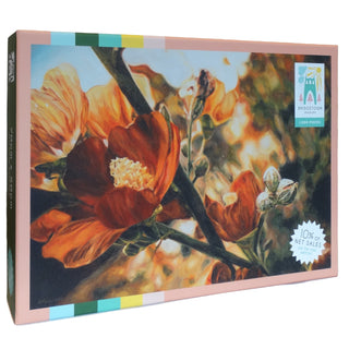 Bridgetown Puzzles’ Sedona | 1,000 Piece Jigsaw Puzzle features a close-up illustration of orange flowers and green stems by artist Betsy LeVine, comes with a soft-touch finish, and includes a label noting that 10% of net sales go to artists.
