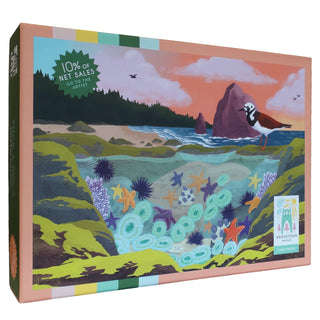 The Tidepool | 1,000 Piece Jigsaw Puzzle from Bridgetown Puzzles features illustrated tidepools with sea stars, urchins, a bird, and coastal scenery by artist Elena Cronin. The box has a soft-touch finish and includes a label stating that 10% of net sales go to the artist.