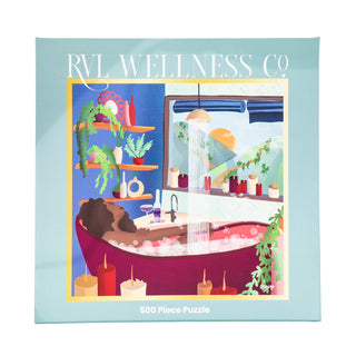 A box labeled RVL Wellness Co. holds the "Protect Your Peace" 500-piece puzzle featuring a person relaxing in a bubble bath, surrounded by candles and plants with sunlight streaming through a window.