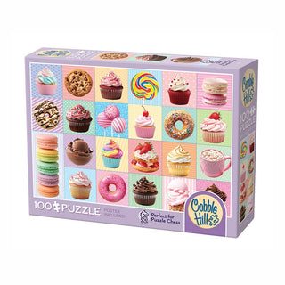 The Cobble Hill Yum Yums 100 Piece Jigsaw Puzzle features large, easy-to-handle pieces and showcases colorful cupcakes, cookies, macarons, and sweets on a pastel background.