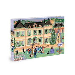 Illustration from Olleo Puzzles' "Wedding Day" 500-piece jigsaw shows a grand yellow mansion with people, cameras, and dogs gathered for a family photo, plus a festive tree and cakes on the lawn.