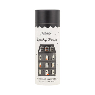Presented in a tall cylindrical container, the My Mind’s Eye Spooky House | 525 Piece Jigsaw Puzzle features vibrant illustrations of a haunted house and playful ghosts in a unique house-shaped design, perfect for Halloween fun.