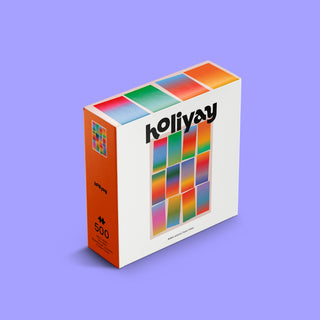 The Lueurs Solaires 500 piece jigsaw puzzle by Holiyay Puzzles features a colorful, abstract grid design on a white background with a premium matte finish, displayed against a purple surface.