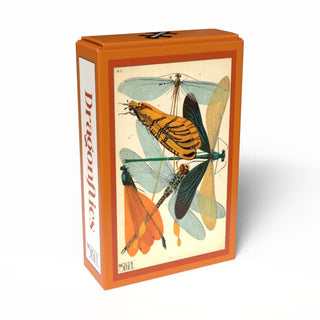 Here’s a revised sentence using your product data: The Dragonflies | 99 Piece Jigsaw Puzzle from Penny Puzzle comes in an orange box featuring an illustrated dragonfly print on the front and the word “Dragonflies” in red text along the side against a white background. Inspired by E. A. Séguy, this vintage mini puzzle brings Art Deco elegance to your collection.