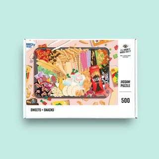 The Sweets + Snacks | 500 Piece Jigsaw Puzzle by Ill Know It When I See It features Asian sweets and snacks on a pink background. The recycled box is labeled SWEETS + SNACKS.