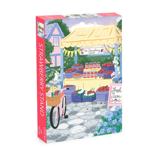 The Olleo Puzzles "Strawberry Stand" 500 piece jigsaw puzzle features a charming strawberry market scene with baskets of strawberries, jam jars, a pink bike, and a cozy cottage in a village backdrop.