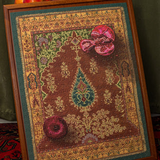 A completed Royal Rumman 500 Piece Jigsaw Puzzle by Laila Luxury Puzzles, featuring a decorative, ornate Persian rug design with flowers and pomegranates, elegantly displayed in a wooden frame.