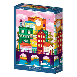 The Pieces & Peace La Ville Sur L'eau 500-piece jigsaw puzzle features a colorful cityscape over a river with swans. Illustrated by Romane LaPierre and made in France, it’s a unique addition to any puzzle collection.