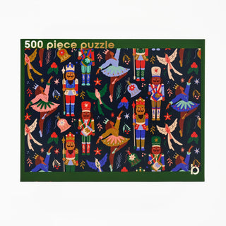 Merry Nutcracker 500 Piece Jigsaw Puzzle box featuring a repeating pattern of nutcrackers, ballerinas, birds, and holly on a dark blue background.