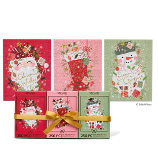 The WerkShoppe Christmas Wishes | 250 Piece Jigsaw Puzzle Set includes three completed holiday-themed puzzles—Santa, a stocking, and a snowman—displayed above their matching boxes and elegantly tied together with a gold ribbon, making it the ideal festive gift for any jigsaw puzzle enthusiast.