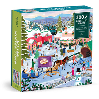 The Galison Little Winter Town | 300 Piece Jigsaw Puzzle features a vibrant winter village scene with people, a horse-drawn sleigh, snowy houses, and trees.