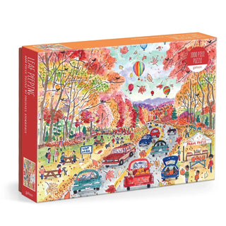 Enjoy the beauty of the season with Galison’s Michael Storrings Leaf Peeping 1,000 Piece Jigsaw Puzzle, capturing a lively autumn scene filled with cars, people, colorful fall trees perfect for leaf peeping, hot air balloons, and a cozy roadside farm stand.
