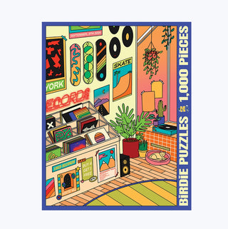A colorful illustration of a retro music store filled with vinyl records, plants, posters, and a sunlit window is featured on the box of Birdie Puzzles’ “Left of the Dial” 1,000 Piece Jigsaw Puzzle. This vibrant hand-illustrated set is crafted from recycled chipboard for eco-friendly enjoyment.