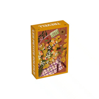 Rectangular Les Petits Soleils | 99 Piece Jigsaw Puzzle box featuring a still life illustration of yellow mimosa flowers, gardening shears, and a plaid cloth on a wooden table.