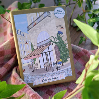 The Café Du Palais 100 Piece Jigsaw Puzzle by Pièce Rapportée features an illustrated French café scene—ideal for inspiring wanderlust or as a charming addition to your travel collection.