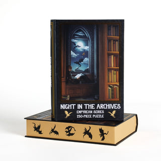 A 250-piece jigsaw puzzle titled Night in the Archives from Kingdom of Threads stands upright on another book-shaped keepsake box, both adorned with dragon silhouettes and a magical library scene—a perfect Fourth Wing-inspired puzzle for fans of enchanting adventures.