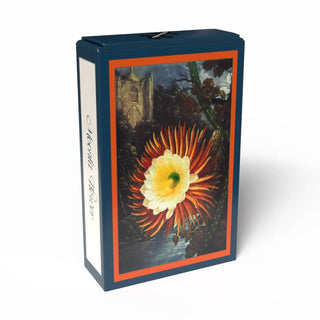 A rectangular box from Penny Puzzle features an illustration of an orange and white flower with green leaves, set against a richly detailed dark background with a building—evoking the botanical artistry of the Temple of Flora. The side reads: Moonlit Flower | 99 Piece Jigsaw Puzzle.