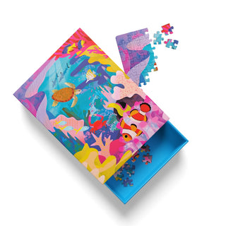 A vibrant Great Barrier Reef | 99 Piece Jigsaw Puzzle by Ohh Deer is partly assembled, with its ocean-themed pieces and box open, spilling colorful sea creature illustrations onto a white background—an ideal choice for snorkeling puzzle fans and underwater adventure enthusiasts.