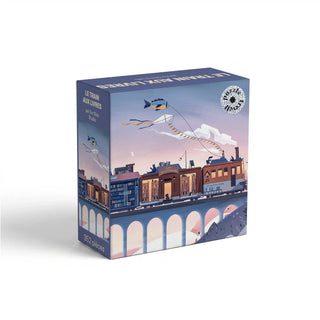 A Le Train Aux Livres 352 Piece Jigsaw Puzzle box featuring an illustration of a train made of books traveling across a bridge under kites.