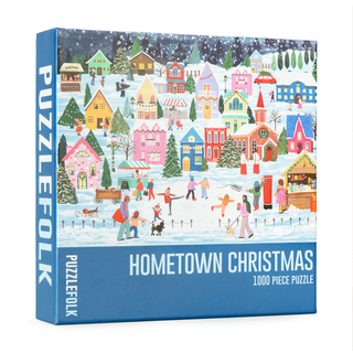 The Hometown Christmas | 1,000 Piece Jigsaw Puzzle by Puzzlefolk features a festive small-town holiday scene with people skating and decorated houses.