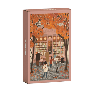 The La Librairie 99 Piece Jigsaw Puzzle by Piecely features people outside a bookstore with autumn trees, made from recycled cardboard and packaged plastic-free.