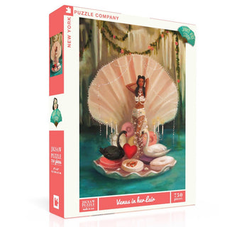 The “Venus in her Lair” 750 piece jigsaw puzzle by New York Puzzle Company features Janet Hill’s whimsical art: a woman as Venus in a shell, with candles, swans (including a black one), and a heart. Text reads "Venus in her Lair.