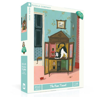 The New Tenant is a 750-piece jigsaw puzzle by New York Puzzle Company featuring Janet Hill’s art of a black and white cat exploring a dollhouse in a vintage teal room with framed artwork.