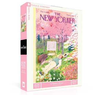 The New York Puzzle Company’s “A Painter’s Dream” 1,000 piece jigsaw puzzle features a 1949 New Yorker cover of an artist painting under pink blossoming trees.