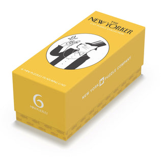 A yellow rectangular box labeled Cat Mini Puzzle Collector’s Set by New York Puzzle Company, featuring an illustration of a person holding a book and a cat. This delightful set includes six 100-piece jigsaw puzzles, making it the perfect gift for cat lovers and capturing the whimsical spirit of feline companionship with charming New Yorker designs.