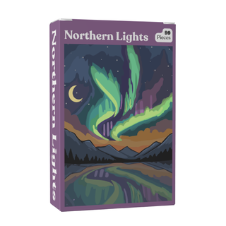 The Puzzledly Northern Lights | 99 Piece Jigsaw Puzzle features ribbon-cut pieces and an illustrated aurora borealis over mountains, trees, and a lake at night. This pocket-sized puzzle is ideal for on-the-go fun.