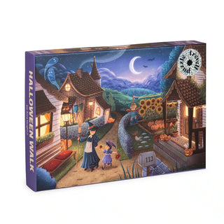 The Trevell Halloween Walk 1,000 piece jigsaw puzzle features a whimsical Halloween village at night, with costumed trick-or-treaters roaming among festively decorated houses under bright moonlit skies.
