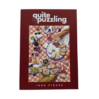 Enjoy hours of fun with Quite Puzzling’s Piccole Gioie, a 1,000 piece jigsaw puzzle featuring an illustrated picnic scene with food and drinks on a red checkered tablecloth—ideal as a coffee table puzzle.