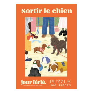 Illustration of dogs on leashes meeting on grass with people nearby. Text reads: Sortir Le Chien | 100 Piece Jigsaw Puzzle by Jour Férié. A charming puzzle made in France.