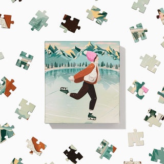 The Skater | 100 Piece Jigsaw Puzzle by Ordinary Habit features a hand-drawn scene of ice skating on a frozen lake with mountain backdrops—an ideal pick for anyone who enjoys charming winter puzzles.
