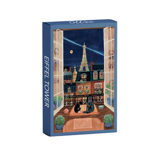 The Eiffel Tower | 99 Piece Jigsaw Puzzle by Olleo Puzzles features a charming illustrated Parisian balcony scene with two cats, potted plants, and the Eiffel Tower glowing at night—perfect for lovers of Parisian apartment puzzles.