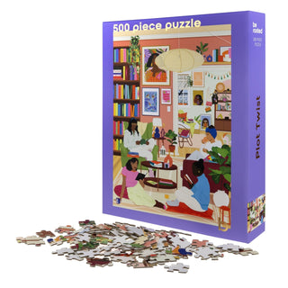 The Be Rooted Plot Twist | 500 Piece Jigsaw Puzzle features a vibrant scene of four women reading in an art-filled living room, making it a perfect screen-free activity or book lover gift. Puzzle pieces are displayed in front of the box.