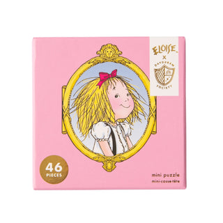 A pink box labeled "Eloise | 46 Piece Jigsaw Puzzle" by Jollity & Co. features a smiling blonde girl with a red bow, part of the Eloise collection inspired by the Plaza Hotel.