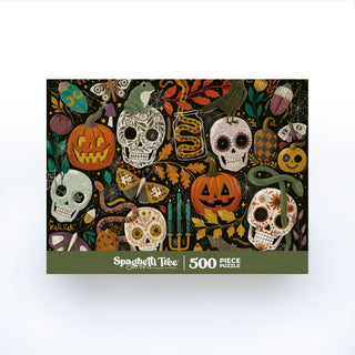 The Creepy Crawlies 500 Piece Jigsaw Puzzle by Spaghetti Tree features a colorful Halloween-themed illustration with skulls, pumpkins, candles, a crow, and various decorative motifs. This randomly cut puzzle offers a delightful challenge for puzzle enthusiasts and spooky season fans alike.