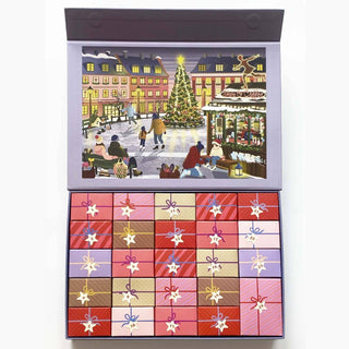 A beautifully illustrated winter scene of people gathered around a Christmas tree in a town square appears beneath the ViSSEVASSE Skate & Coffee Puzzle Advent Calendar—a festive set featuring 24 compartments to open, each revealing a section of the 1,000 piece jigsaw puzzle for daily discoveries, reminiscent of the wonder and anticipation of a classic holiday calendar.