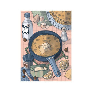 A delightful illustration of a skillet with a crepe and butter, classic ingredients, and crepes on a patterned cloth—featured in the Trevell Crepes | 99 Piece Jigsaw Puzzle.