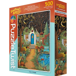 The Cozy Cottage | 500 Piece Jigsaw Puzzle by PuzzleTwist features an illustrated autumn cottage scene with colorful trees, a pond, and charming hidden details from the Something's Amiss series.