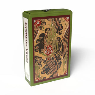 Green box labeled Crimson Vines | 99 Piece Jigsaw Puzzle by Penny Puzzle, featuring an intricate floral and vine pattern in red, green, and gold on the front—evoking E. A. Séguy’s bold Art Deco style—ideal for vintage mini puzzle enthusiasts and collectors of decorative keepsakes.