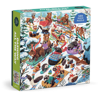 A 500-piece winter puzzle by Galison titled “Dashing All the Way,” featuring illustrated animals sledding in a snowy forest, with artwork by Lucia Baertl.