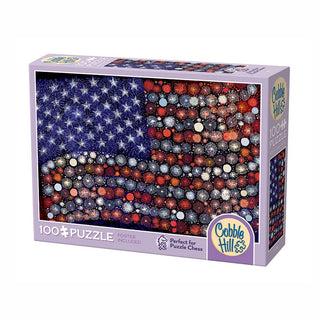 Cobble Hill’s Fireworks 100-piece jigsaw puzzle features large random-cut pieces and an abstract American flag made of marbles, packaged in a purple box.