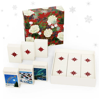 The Cloudberries 12 Mini Puzzles of Christmas gift box includes twelve small boxes, each with an 80-piece festive puzzle and a red star design. Three holiday-themed puzzles are shown, set against a snowflake-patterned background.