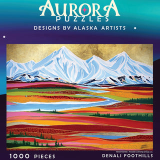Aurora Puzzles’ Denali Foothills 1,000 piece jigsaw puzzle features a vibrant painting of layered fields, rivers, and snowy mountains by Alaska artists.