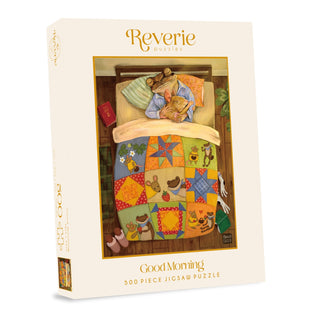 Box for Reverie Puzzles’ Good Morning | 500 Piece Jigsaw Puzzle, featuring an illustration of a child and cat sleeping under a colorful patchwork quilt.