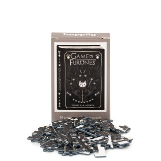 The Game of Furones | 99 Piece Mini Jigsaw Puzzle by Happily Jigsaw Puzzles features a charming cat illustration on the box, displayed behind scattered puzzle pieces.