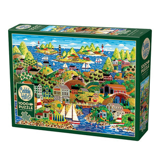 The Cobble Hill "Home From the Sea" 1,000 piece puzzle features Anthony Kleem's vibrant folk art of a bustling coastal town with boats, houses, trees, mountains, and people.